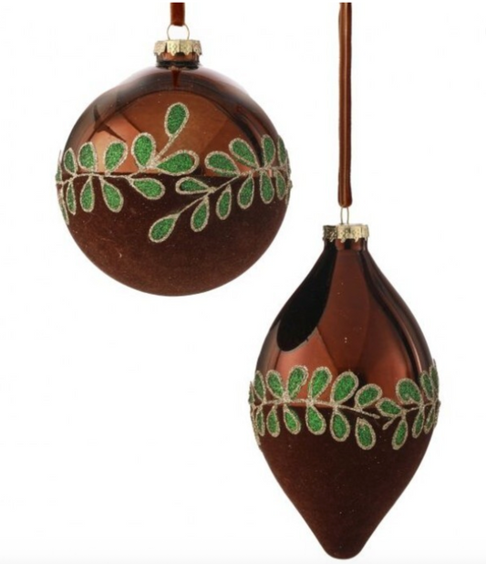 Two brown ornaments with green leaf patterns on a white background